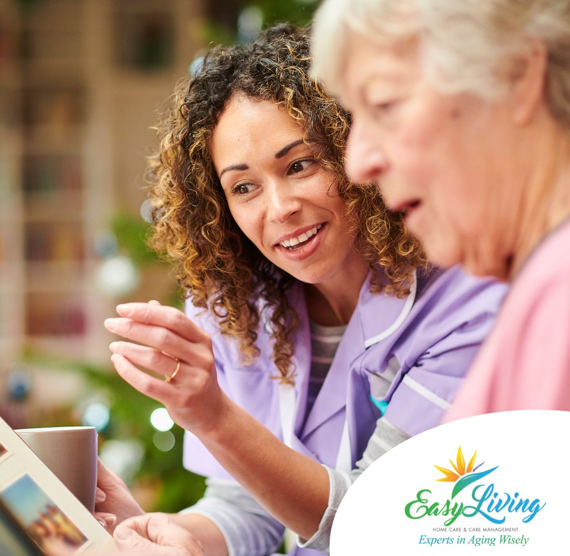 A caregiver helps an older client remember memories from a photo album, representing how dementia care can help those in Clearwater.